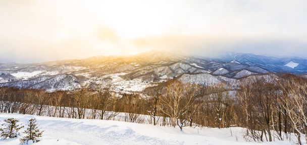 北海道札幌市で日没時に冬の季節は雪に木の周りの山と美しい風景 - 写真・画像