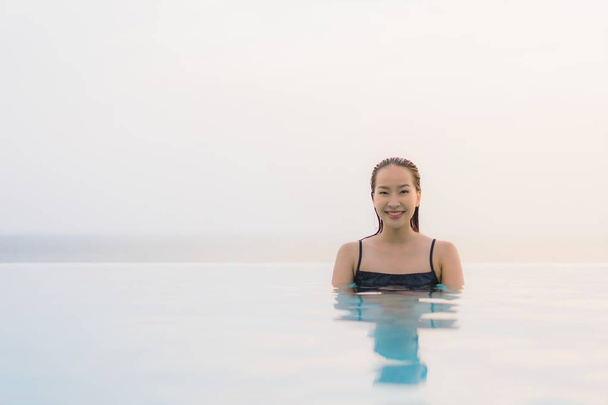 Portrait beautiful young asian woman happy smile relax around swimming pool in hotel resort for leisure travel and vacation at sunset - Foto, Imagem