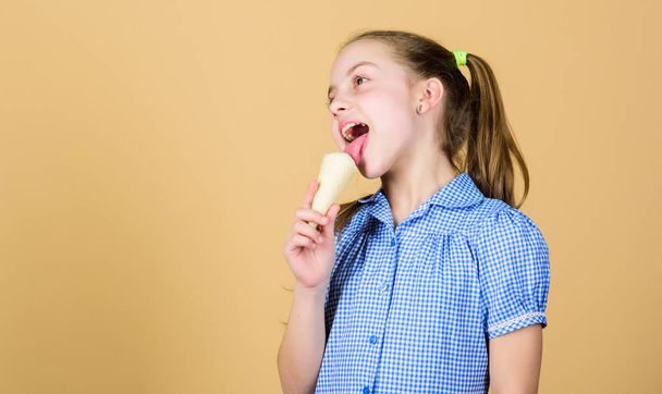 Ice cream makes her happy. Cute little girl eating ice cream. Small child licking ice cream in cone. Adorable kid enjoy frozen iced cream dessert in waffle, copy space - Foto, Bild