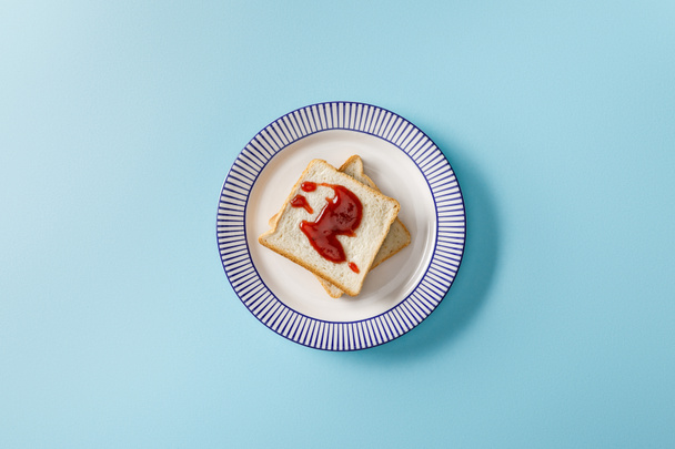 top view of toasts with jam on plate on blue background - Foto, imagen