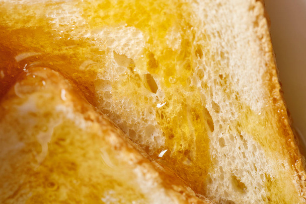 close up view of toasts with honey  - Photo, Image