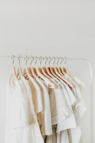 Женская одежда на вешалке. Минимальная модная композиция на белом фоне. Концепция женского блога
. - Фото, изображение