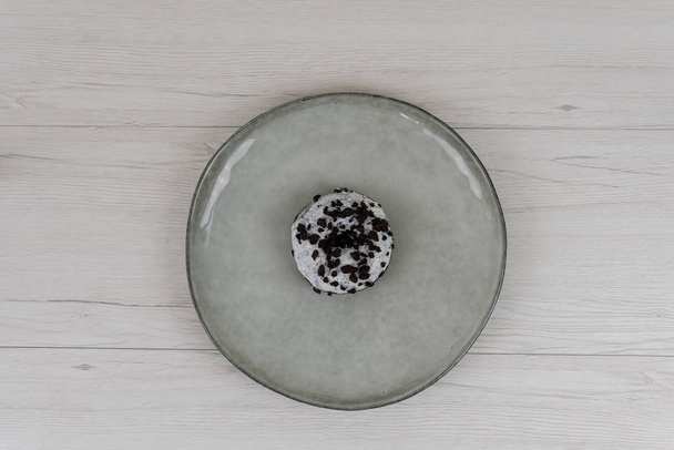 Ciambelle in un piatto su sfondo di legno bianco, vista dall'alto
 - Foto, immagini