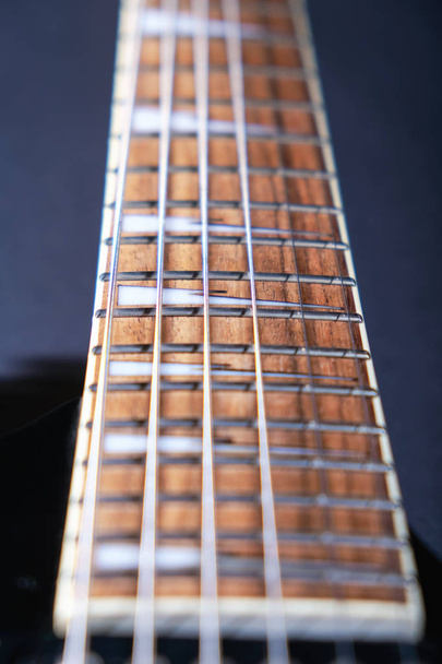 Electric guitar macro shot of a fretboard.Soft selective focus. On black background - Фото, изображение
