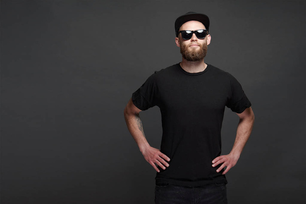 Hipster handsome male model with beard wearing black blank baseball cap with space for your logo - Foto, afbeelding