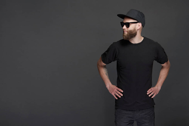Hipster handsome male model with beard wearing black blank baseball cap with space for your logo - Photo, Image