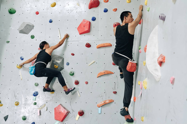 Deportiva pareja disfrutando de bouldering en centro de escalada
 - Foto, imagen