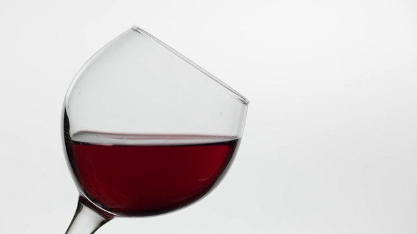 Close-up van een druppel vallende in glas met rode wijn. Rose wijn op witte achtergrond - Video