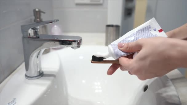 Woman squeeze tube and put toothpaste on brush. - Video
