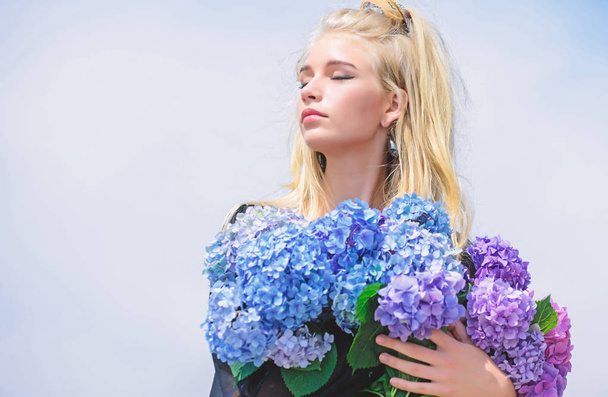 Fashion trend spring. Meet spring with new perfume fragrance. Flowers tender fragrance. Fashion and beauty industry. Girl tender fashion model hold hydrangea flowers bouquet. Makeup and fashion style - Foto, afbeelding