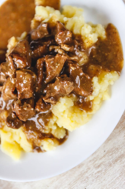 Braised beef, beef stroganoff with gravy on mashed potatoes. Clo - Photo, Image