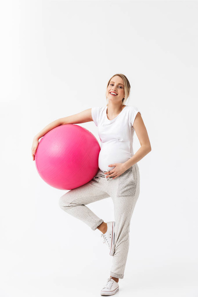 妊娠中の女性フィット持株ボールを笑顔と腹白で隔離を指して ロイヤリティフリー写真 画像素材