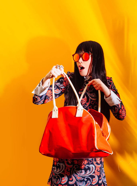 αγοραστής γυναίκα κίτρινο φόντο κόκκινο τσάντα σκιά μελαχρινή γυαλιά αστεία ψώνια - Φωτογραφία, εικόνα
