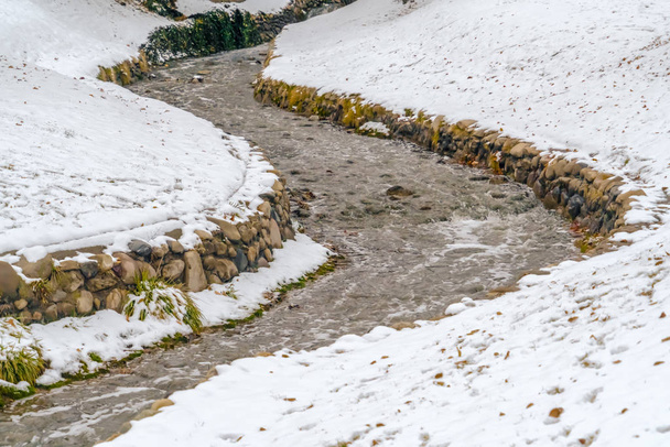 Kurvenreicher Bach inmitten des vereisten Bodens auf einem Park in der Salzseestadt im Winter - Foto, Bild