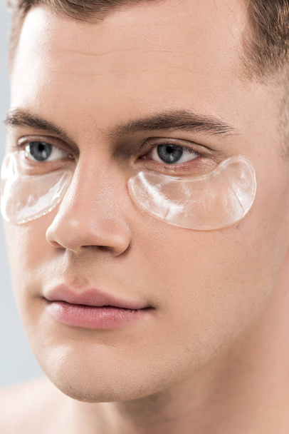 Portret van knappe jonge man met Eye patches op zoek weg - Foto, afbeelding