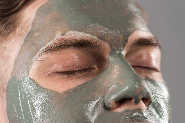 cropped view of young man with clay mask isolated on grey - Photo, Image