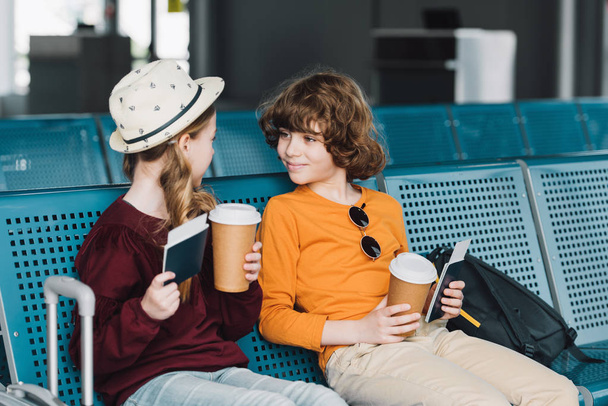 aranyos preteen gyerekek ül a váróteremben a kávé, hogy menjen és útlevél - Fotó, kép