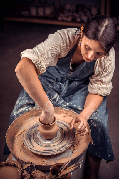 Κομψό θηλυκό Μάστερ δείχνει τη διαδικασία της φτιάχνοντας κεραμικά πιάτα χρησιμοποιώντας την παλιά τεχνολογία. Φτιάχνοντας κεραμικά πιάτα. - Φωτογραφία, εικόνα