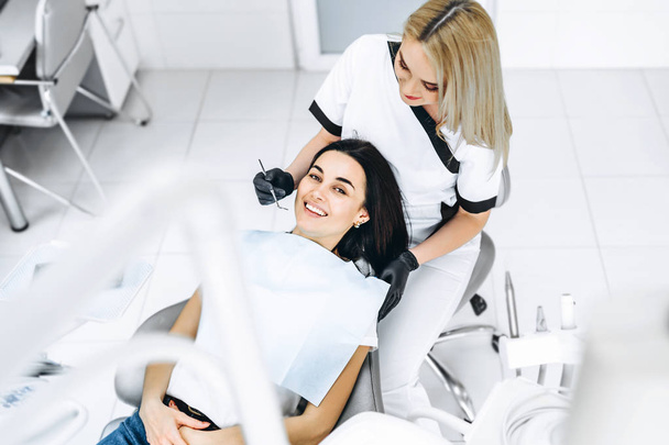 Pretty young female dentist making examination and treatment for - 写真・画像