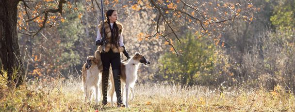 Portrait of a beautiful girl hunter with dogs - Fotoğraf, Görsel