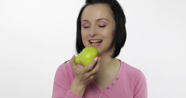 Frau isst frische Birne und sagt Yum. Mädchen beißt zuerst und will beißen - Filmmaterial, Video