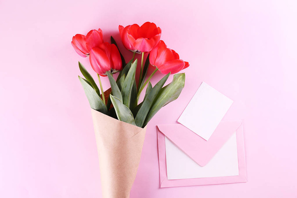 Minimalistic composition with red tulips bouquet in paper wrapping. - Valokuva, kuva