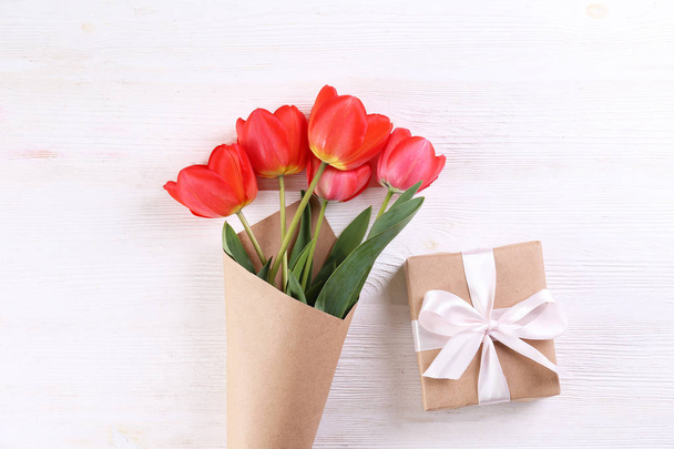 Minimalistic composition with red tulips bouquet in paper wrapping. - Foto, Bild