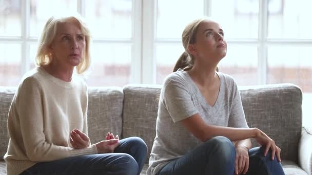 Stubborn annoyed young daughter ignoring worried stressed old mother arguing - Felvétel, videó