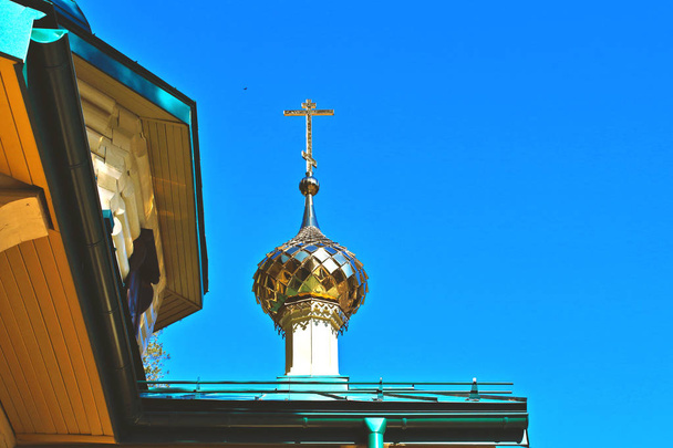 Dômes d'or avec croix sur la chapelle de l'église du temple, un bâtiment chrétien religieux de bois bûches vue du bas
 - Photo, image