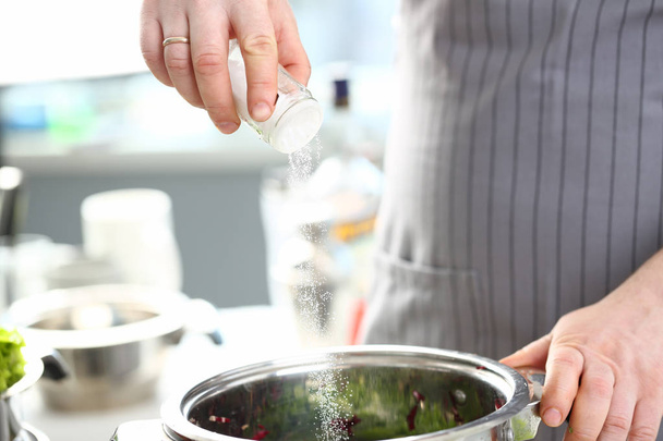 Doigts de chef mettant la casserole sel de mer blanche
 - Photo, image