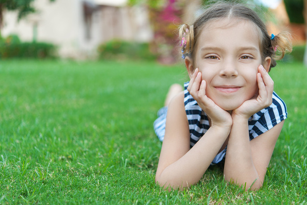 beautiful smiling girl lies on green grass - Fotografie, Obrázek