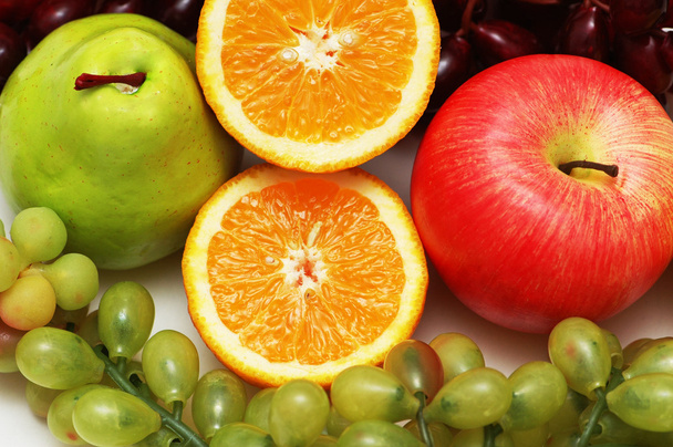 Puolileikattu appelsiini ja muut hedelmät
 - Valokuva, kuva