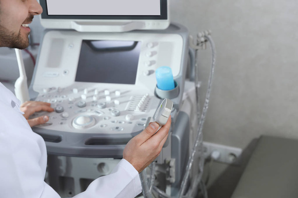Sonographer using modern ultrasound machine in clinic, closeup - Fotografie, Obrázek