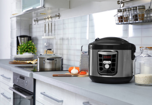 Modern multi cooker and products on table in kitchen. Space for text - Foto, Imagem