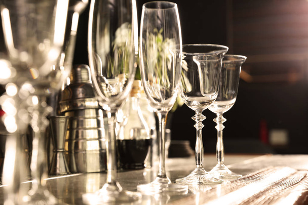 Different empty clean glasses on counter in bar, closeup - Foto, imagen