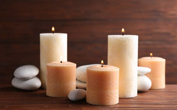 Composition of burning candles and spa stones on table - Foto, Bild