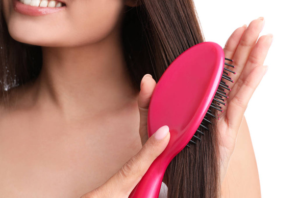 Woman with hair brush on white background, closeup - Foto, afbeelding