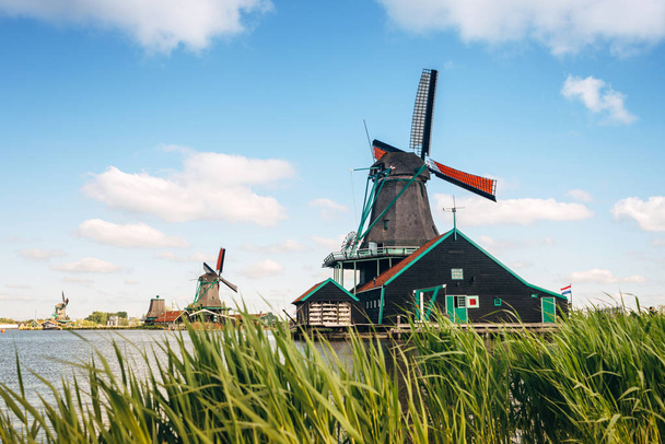 Molinos de viento holandeses tradicionales sobre fondo de cielo azul, Kinderdijk, Países Bajos
 - Foto, imagen