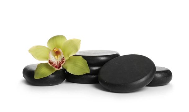 Spa stones with beautiful orchid flower on white background - Foto, afbeelding