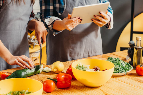 online recipe tablet women chopping veggies salad - Foto, Imagen
