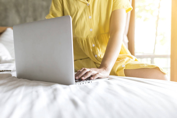 chica que trabaja con un ordenador portátil en su cama, las mujeres que utilizan el ordenador portátil para en
 - Foto, Imagen