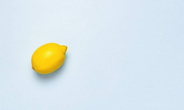 Ripe juicy lemons on pastel blue background. Lemon fruit, citrus minimal concept, vitamin C. Creative summer food minimalistic background. Flat lay, top view, copy space. - Fotó, kép