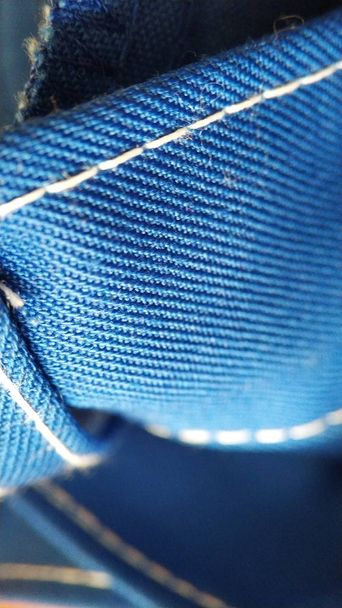 Текстура синей рабочей одежды с белым стежком крупным планом
 - Фото, изображение