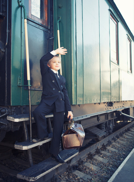 menino com uma mala no trem retrô
 - Foto, Imagem
