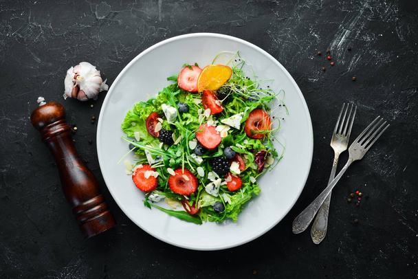 Salad. Salad of arugula, blue cheese, strawberries and blueberries. Top view. - Photo, Image