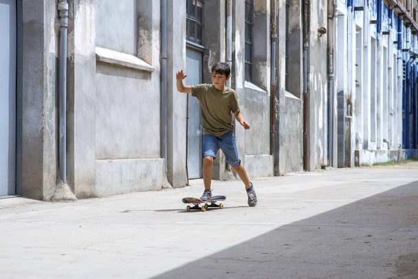 Vooraanzicht van vrolijke Skater jongen rijden op de stad in een zonnige dag - Foto, afbeelding