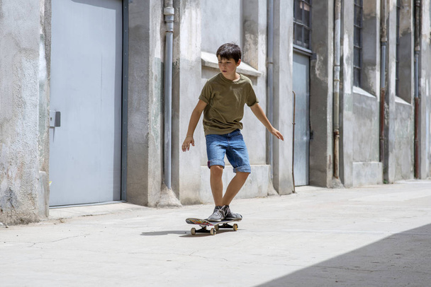 晴れた日に街に乗る陽気なスケーター少年の正面図 - 写真・画像