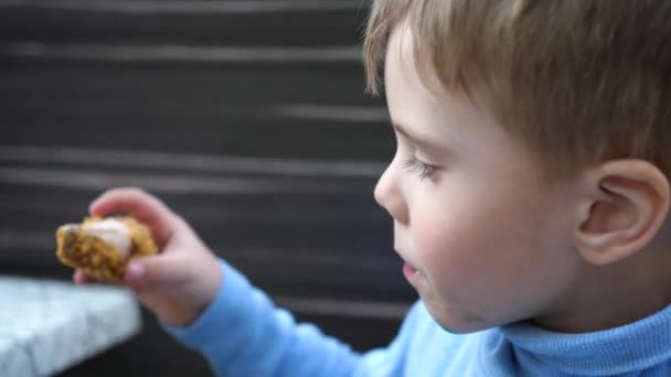 Baby eszik sült csirke egy gyorsétteremben, közelről - Felvétel, videó