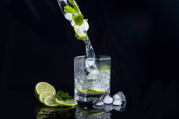 Zomer cocktail mojito met splash op zwarte achtergrond - Foto, afbeelding