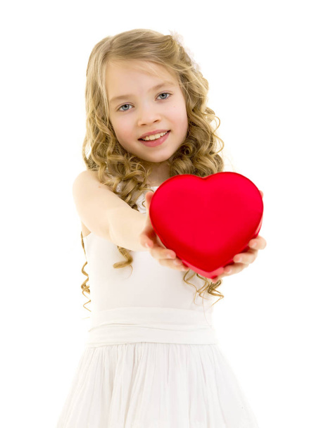 A little girl is holding a heart. - Valokuva, kuva